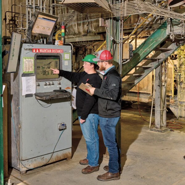 Two males learning and pointing in GAF manufacturing plant