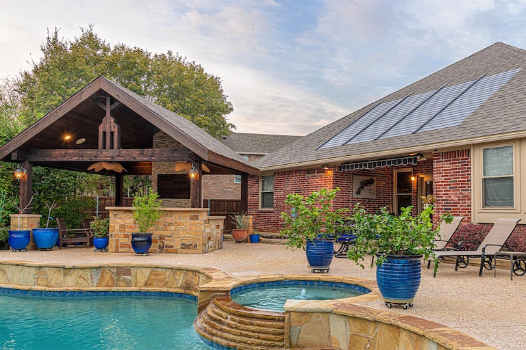Brick home with pool featuring Timberline solar roof shingles