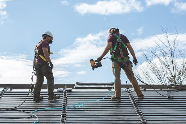 Contractor installing solar roofing shingles