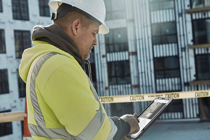 Commercial roofer using GAF QuickSite property data report on tablet