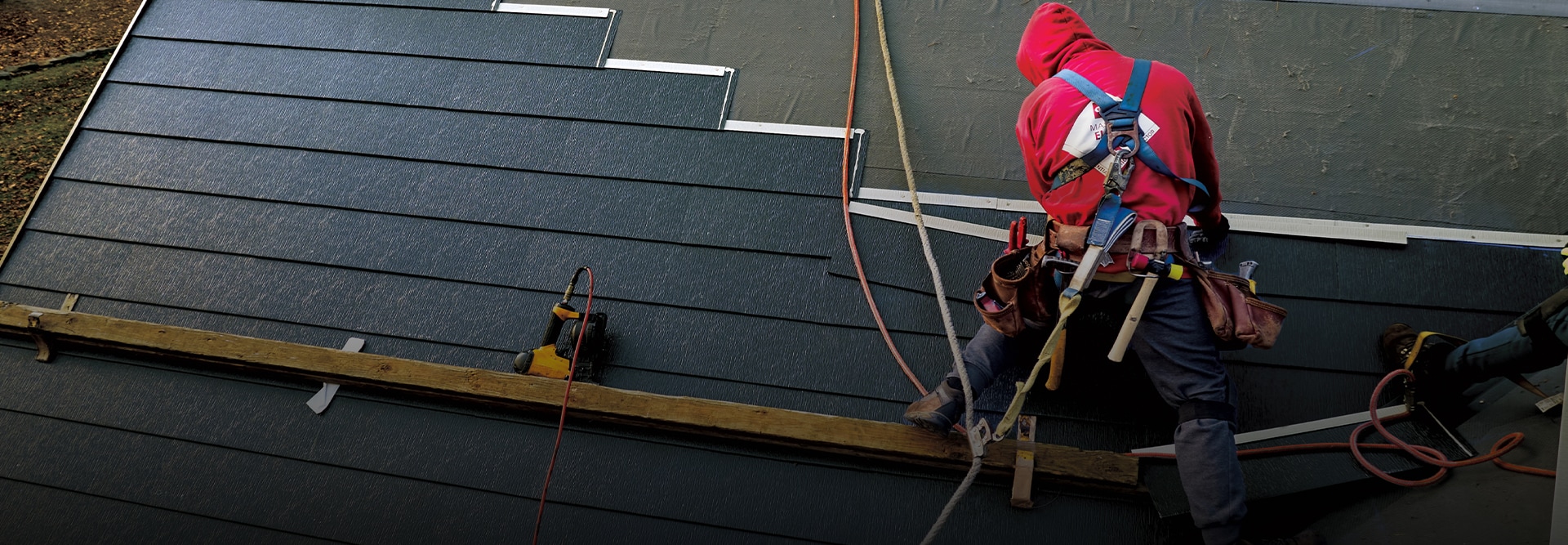 Certified GAF roofing contractor near you installing a metal roof shingle on a home