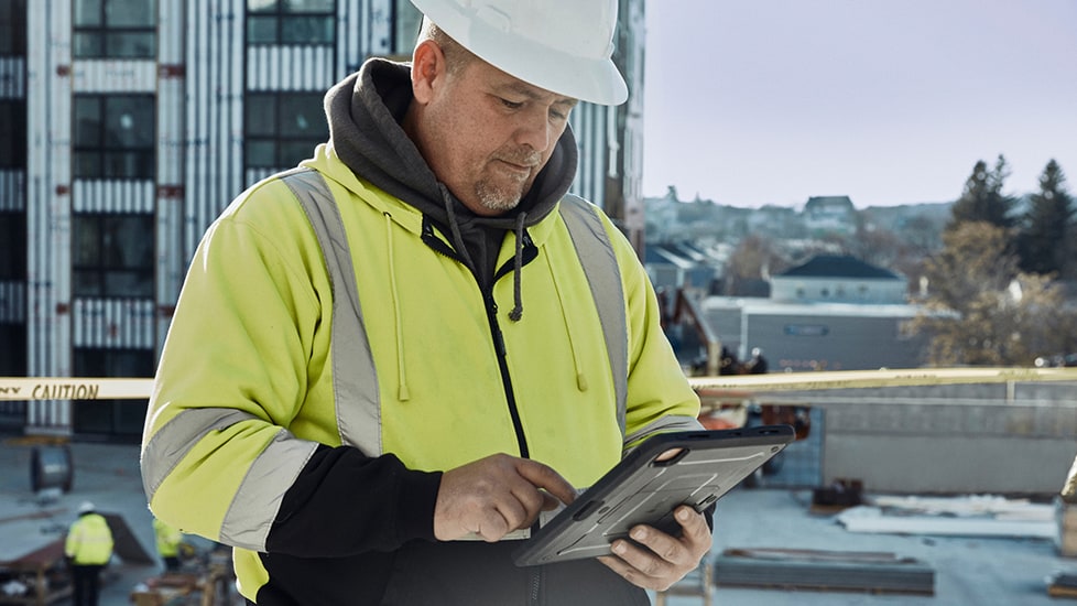 Commercial roofing contractor on job using tablet     