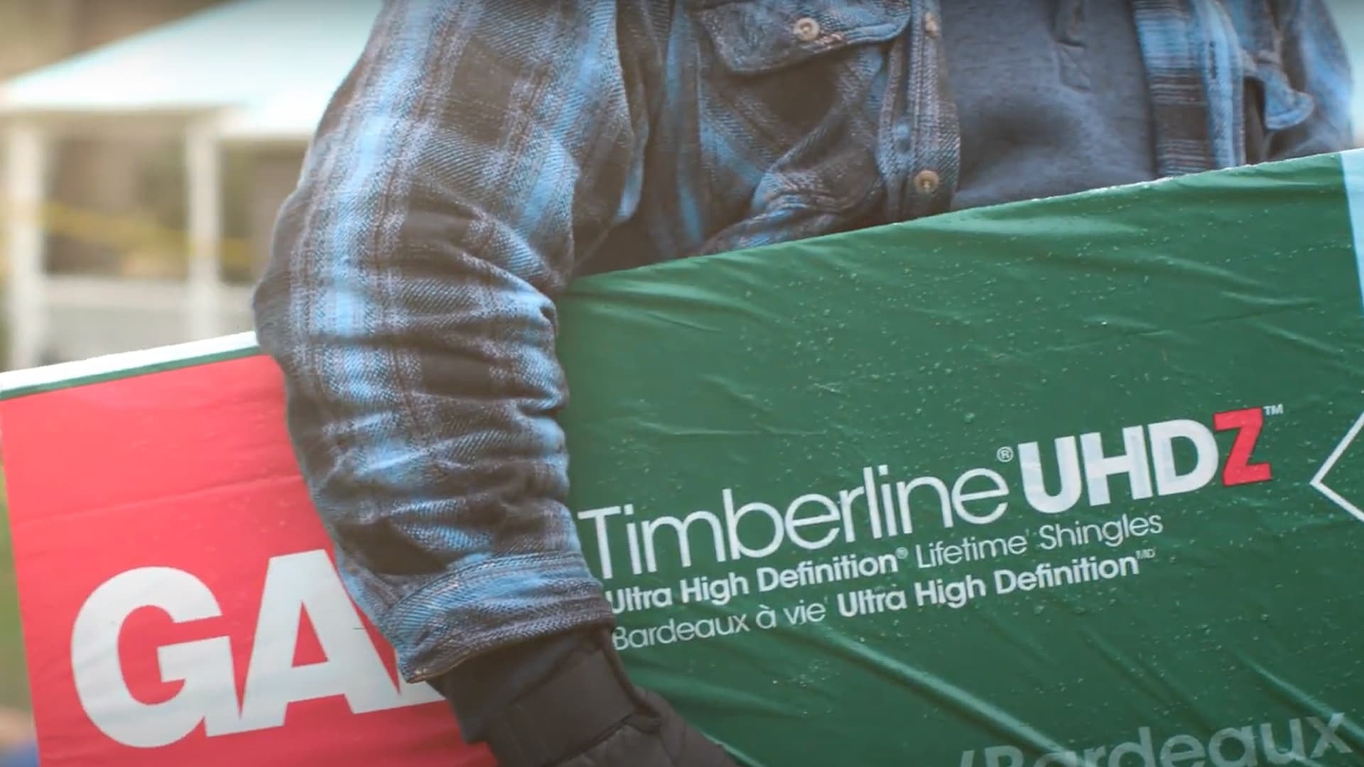 GAF certified roofer carrying package of Timberline UHDZ shingles