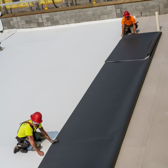 Commercial contractors using wide TPO rolls on roof to save time