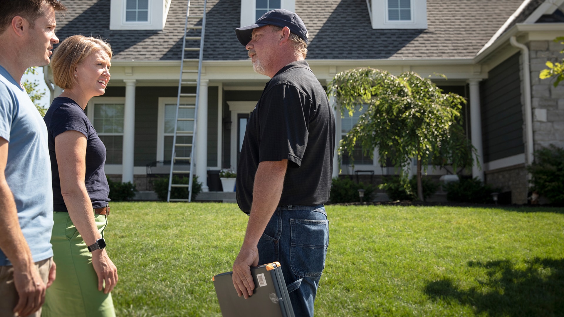 Roofing contractor outside home discussing roof insurance claim